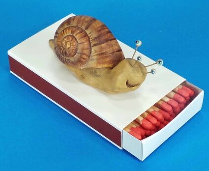 Zündholzschachtel mit aufgeklebter Schnecke dekoriert.